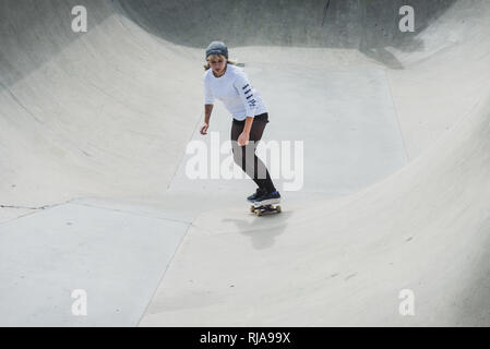 Una ragazza adolescente pattinaggio a livello Skatepark in Brighton, East Sussex, Inghilterra. Foto Stock