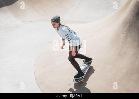 Una ragazza adolescente pattinaggio a livello Skatepark in Brighton, East Sussex, Inghilterra. Foto Stock