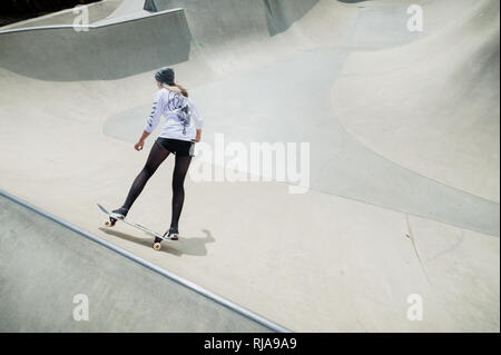 Una ragazza adolescente pattinaggio a livello Skatepark in Brighton, East Sussex, Inghilterra. Foto Stock