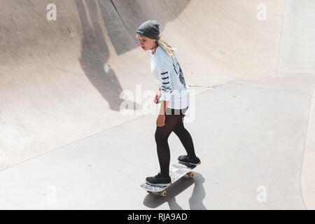 Una ragazza adolescente pattinaggio a livello Skatepark in Brighton, East Sussex, Inghilterra. Foto Stock