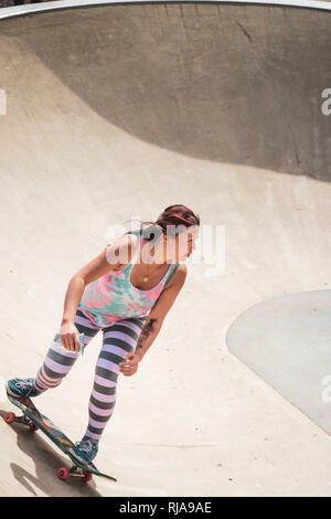 Una ragazza adolescente pattinaggio a livello Skatepark in Brighton, East Sussex, Inghilterra. Foto Stock