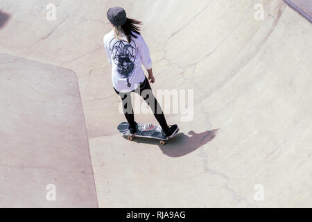 Una ragazza adolescente pattinaggio a livello Skatepark in Brighton, East Sussex, Inghilterra. Foto Stock