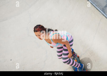 Una ragazza adolescente pattinaggio a livello Skatepark in Brighton, East Sussex, Inghilterra. Foto Stock