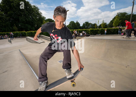 Un uomo di pattinaggio a livello Skatepark in Brighton, East Sussex, Inghilterra. Foto Stock