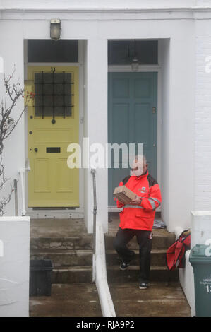 Un Royal Mail postino recapita posta e pacchi di proprietà residenziale. Foto di James Boardman Foto Stock