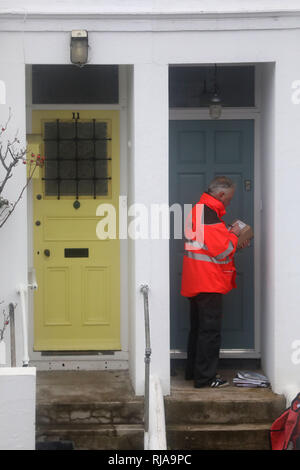 Un Royal Mail postino recapita posta e pacchi di proprietà residenziale. Foto di James Boardman Foto Stock