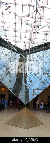 La Pyramide Inversée (piramide invertita) è un lucernario costruito nel Carrousel du Louvre; shopping mall; di fronte al Museo del Louvre; in Francia. La piramide segna l'intersezione delle due principali strade pedonali e orienta i visitatori verso l'entrata del museo. Direttamente sotto la punta della verso il basso di puntamento a piramide in vetro, una piccola piramide di pietra è sul pavimento. Le punte dei due piramidi quasi toccare. La Pyramide Inversée è stata progettata dagli architetti I.M. Pei, e installati nel 1993. La piramide rovesciata figure di rilievo nella conclusione di pagine di Dan Brown best seller internazionale il da Foto Stock