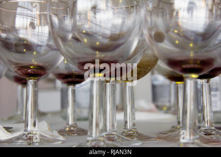 Bicchieri di vino e bottiglie sul tavolo dopo l'apertura della mostra e presentazione. Foto Stock