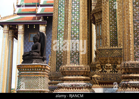 Nero statua del Buddha e colonne modello in dettaglio il Wat Phra Kaew tempio entro il Grand Palace complesso a Bangkok, in Thailandia Foto Stock