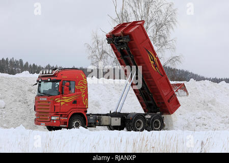 Salo, Finlandia - 2 Febbraio 2019: Rosso Scania R580 ribaltabile elevatore scarica snow cancellato dalle strade e parcheggi comunali neve area di dumping. Foto Stock