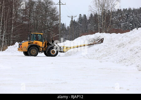 Salo, Finlandia - 2 Febbraio 2019: Volvo L45F della pala caricatrice gommata neve con attrezzatura di sollevamento al lavoro al comunale di dumping neve area nel sud della Finlandia. Foto Stock