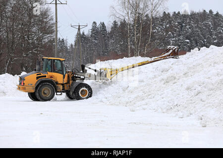 Salo, Finlandia - 2 Febbraio 2019: Volvo L45F della pala caricatrice gommata neve con attrezzatura di sollevamento al lavoro al comunale di dumping neve area nel sud della Finlandia. Foto Stock