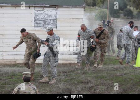 Il California esercito nazionale della guardia Sgt. James W. Peterson, Intel & Supporto Co, quarantesimo divisione di fanteria, sinistra e Sgt. Fernando Carmona, 1113th Transportation Company, 340 Vigili del battaglione di supporto, 224th supporto brigata, ottenere assistenza dal loro sponsor dopo la chiusura di una camera del gas durante i chimici, biologici, radiologici e nucleari (CBRN) evento della California's 2017 miglior guerriero concorrenza nov. 1-5, 2016 a Camp San Luis Obispo San Luis Obispo, California. (Esercito Guardia Nazionale Foto Stock