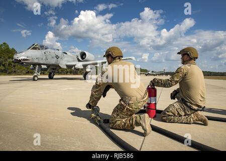 Il personale Sgt. Brandon Earl, sinistra e Staff Sgt. Christopher Dessi, 23d disponibilità logistica squadrone area avanti punto di rifornimento dei membri del team, preparare per il rifornimento di un A-10C Thunderbolt II, assegnato alla 74Fighter Squadron, durante una rapida esercitazione di soccorso, nov. 3, 2016 a Tyndall Air Force Base, Fla. Moody's FARP team è solo uno dei due in combattimento aereo comando e consente alla HC-130J contro il re II a volare in qualsiasi aerodromo e di fare rifornimento di carburante gli aerei a terra in modo che possano tornare rapidamente alla lotta. Foto Stock