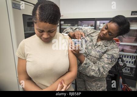 Il personale Sgt. Alicia Roger, Diritto, Medicina Aerospaziale tecnico, 108th ala Medical Group, New Jersey Air National Guard, dà Airman 1. Classe Estate Campbell, 108th ingegnere civile Squadron, il vaccino antinfluenzale a base comuneGuire-Dix Mc-Lakehurst, N.J., nov. 5, 2016. Vaccinazione antinfluenzale sono vincolanti per tutti i membri del servizio. Secondo i centri per il controllo e la prevenzione delle malattie stima tra il 5 e il 20% degli americani di ottenere l'influenza ogni anno. Influenza la vaccinazione può ridurre le malattie influenzali e impedire flu-relativi ricoveri. Foto Stock