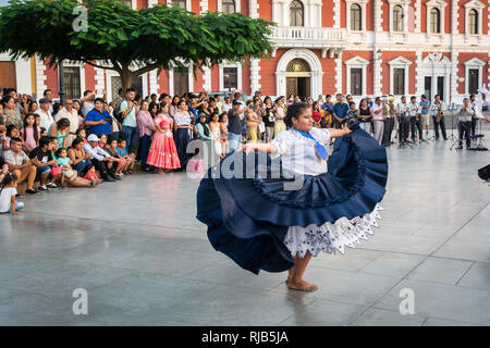 La folla guarda la sua fama Marinera danza di Trujillo, Perú, in stile coloniale e la piazza principale della città. Foto Stock