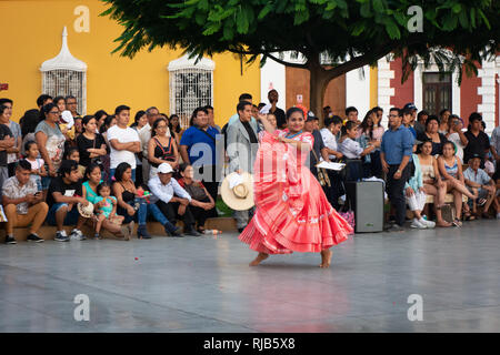 La folla guarda la sua fama Marinera danza di Trujillo, Perú, in stile coloniale e la piazza principale della città. Foto Stock