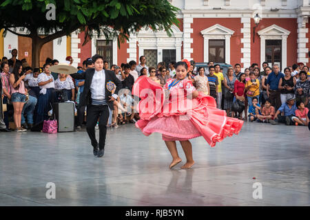 La folla guarda la sua fama Marinera danza di Trujillo, Perú, in stile coloniale e la piazza principale della città. Foto Stock