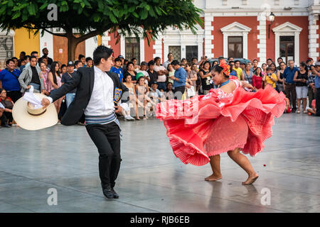 La folla guarda la sua fama Marinera danza di Trujillo, Perú, in stile coloniale e la piazza principale della città. Foto Stock