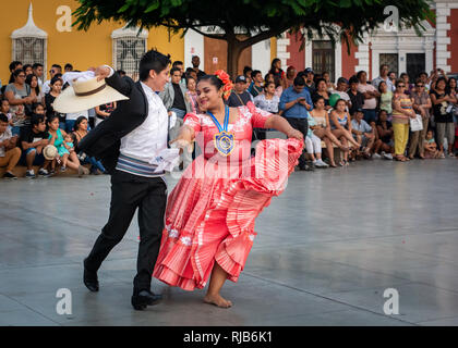 La folla guarda la sua fama Marinera danza di Trujillo, Perú, in stile coloniale e la piazza principale della città. Foto Stock