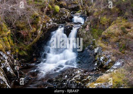 La montagna masterizzare Allt na h-Annaite a cascata verso il basso la collina nel Strathconon, Ross & Cromarty, Scozia. Marzo. Foto Stock