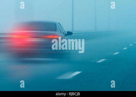 La scarsa visibilità su una strada di nebbia Foto Stock