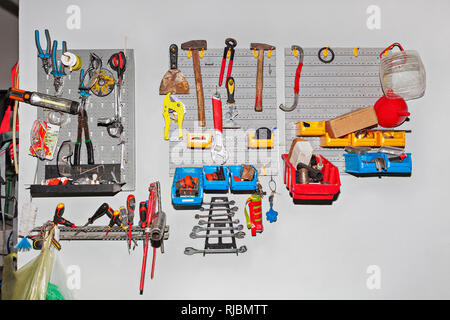 Grande assortimento di strumenti diversi appesa sul muro a workshop - Concetto di riparazione Foto Stock