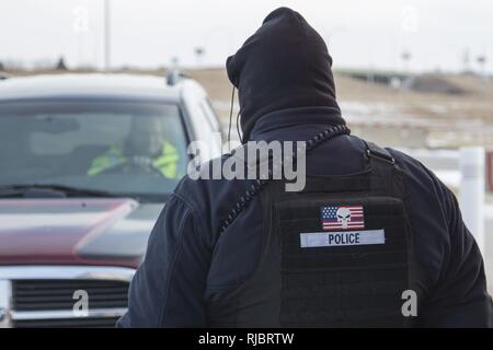 Robert Jones, un militare di specialista di sicurezza con il Nebraska Guardia Nazionale air base a Lincoln, controlli di identificazione di visitatore e conduce le ispezioni del veicolo, 16 gennaio, 2018 mentre il wind chill temperature sulla base rimangano al di sotto dello zero. Jones ha lavorato sicurezza presso la base aerea per gli ultimi tre anni. (Nebraska Guardia Nazionale Foto Stock