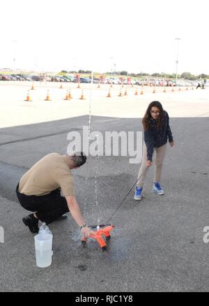 SAN ANTONIO - (nov. 1, 2016) Bridgman, Mich native, Sottufficiali di prima classe Ian MacKay, un campo nucleare assegnato coordinatore marina al reclutamento di quartiere San Antonio, assiste una middle school girl in una bottiglia di acqua il lancio del razzo durante quella ispanica Camera di Commercio CORE4 stelo Expo che si terrà presso il Freeman Expo Hall. MacKay è un 2005 laureato di Bridgman High School. L'expo, costituito un giorno femmina e maschio di giorno, leader in primo piano dall'energia, scienza, computer e industrie aerospaziali e presentata agli studenti l opportunità di incontrare di alto profilo rappresentanti da Fort Foto Stock