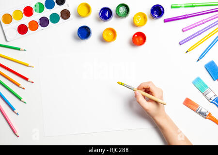 Kid mani inizia a dipingere a tavola con arte forniture, vista dall'alto Foto Stock