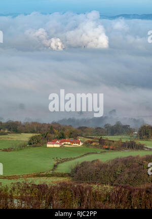 Vista di una casa colonica in via valle e mostra le emissioni dal Grangemouth raffineria di petrolio nella distanza che mostra attraverso la nebbia di mattina. Foto Stock