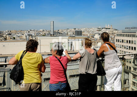 Quattro turisti femmina godere la vista panoramica sopra i tetti di Parigi dalla terrazza sul tetto delle Galeries Lafayette Paris Francia Foto Stock