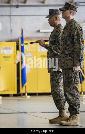 Stati Uniti Marine Corps Sgt. Il Mag. Clemente C. Pearson, off-andando sergente maggiore per sede e Sede Squadron (H&SA), trattiene il personale non ufficiale incaricato spada durante un post e cerimonia di sfiato sul Marine Corps Air-Station Futenma, Okinawa, in Giappone, Gennaio 08, 2018. Sgt. Il Mag. William D. Harrington alleviato Pearson come il sergente maggiore per H&HS. Foto Stock