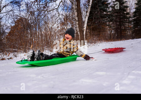 Ragazzo su una slitta a ridere, Wisconsin, Stati Uniti Foto Stock