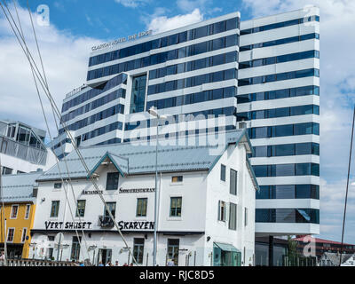 Tromsö city centre, al porto, hotel Clarion 'il bordo", torta a forma di edificio, tradizionale ristorante 'Skarven' , vecchio legno barca a vela, Tromsö, Foto Stock