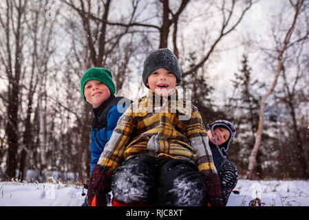 Ritratto di tre bambini seduti su una slitta, Wisconsin, Stati Uniti Foto Stock