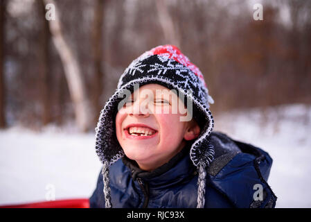 Ritratto di un ragazzo su una slitta a ridere, Wisconsin, Stati Uniti Foto Stock