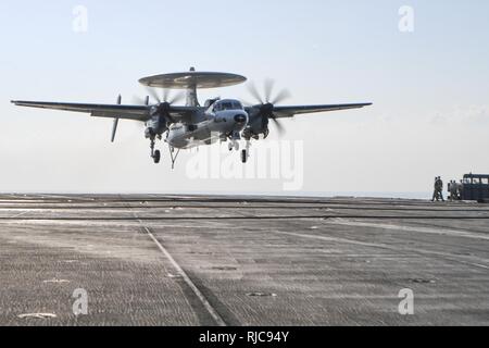 Golfo Arabico (GEN. 9, 2018) E-2C Hawkeye assegnato all'Sunkings del Carrier Airborne Early Warning Squadron (VAW) 116 atterra sul ponte di volo della portaerei USS Theodore Roosevelt CVN (71). Theodore Roosevelt e il suo supporto strike gruppo sono distribuiti negli Stati Uniti Quinta Flotta area di operazioni a sostegno della sicurezza marittima operazioni per rassicurare gli alleati e partner e preservare la libertà di navigazione e il libero flusso di commercio nella regione. Foto Stock