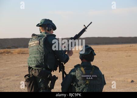 Una Guardia Civil spagnola membro della coalizione assiste ad un soldato iracheno la M4 fucile durante un live esercitazione antincendio presso il Camp Besmaya,, 7 gennaio 2018. Questa formazione fa parte del complesso di Combined Joint Task Force - Funzionamento inerenti risolvere la costruzione di capacità del partner di missione che si concentra sulla formazione e rafforzare la capacità di partnership forze che lottano ISIS. CJTF-funzione OIR è la coalizione globale per sconfiggere ISIS in Iraq e la Siria. Foto Stock