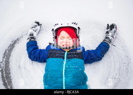 Ragazzo disteso sul lago ghiacciato rendendo un angelo di neve, Wisconsin, Stati Uniti Foto Stock