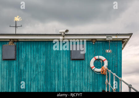 Verde casa sulla spiaggia con una telecamera di sicurezza e salvagente Foto Stock