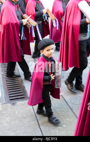 Un giovane bambino gioca un guiro metallico con una banda di strada. Santiago de Compostela, Spagna Foto Stock