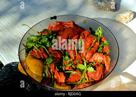 Arrachera materie carni bovine in un recipiente di plastica preparati con condimenti per la cottura alla griglia; carne asada, il coriandolo, limone, arancio. Foto Stock