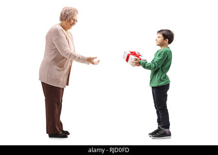 Lunghezza piena ripresa del profilo di un nipote dando una confezione regalo di sua nonna isolata su sfondo bianco Foto Stock