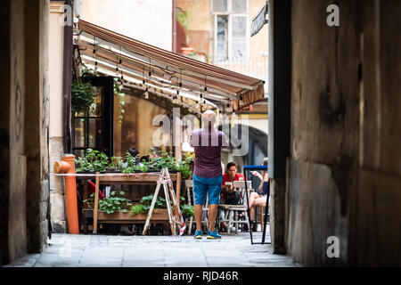 Lviv, Ucraina - 30 Luglio 2018: Street nel centro storico polacco ucraino Lvov città durante il giorno con vecchi edifici d'epoca nella città vecchia e il cafe ristorante nar Foto Stock