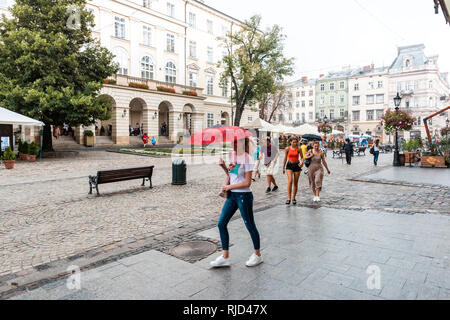 Lviv, Ucraina - 31 Luglio 2018: storico ucraino città polacca in old town Market Square park con gente che cammina sulla strada di ciottoli sulla giornata piovosa um Foto Stock