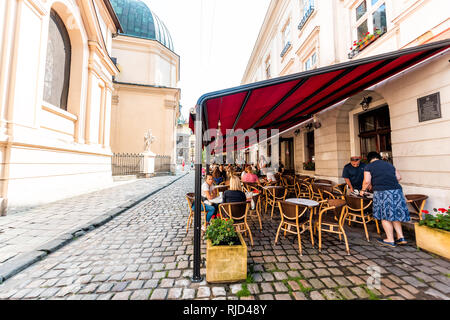 Lviv, Ucraina - 1 Agosto 2018: Street nel centro storico polacco ucraino Lvov città durante il giorno con coperte cafe SVIT/ASFI Kavy nella città vecchia e la gente seduta da Foto Stock