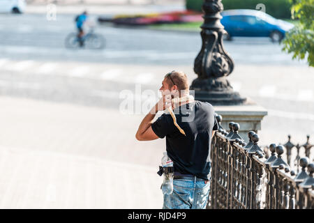 Kiev, Ucraina - 12 agosto 2018: popolo ucraino local uomo a camminare sulla strada tenendo snake indossa intorno al collo del rettile pet a Kiev in estate Foto Stock