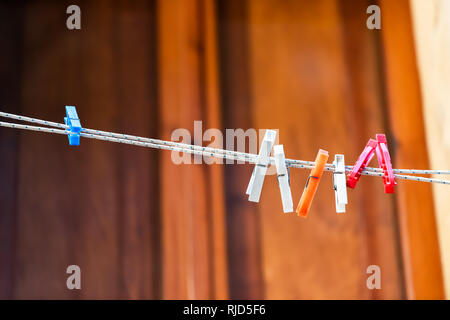 Primo piano isolato di molti Blu Arancione Rosa Bianco clothespins per appendere gli abiti in estate a Siena, Italia con sfondo bokeh di fondo Foto Stock