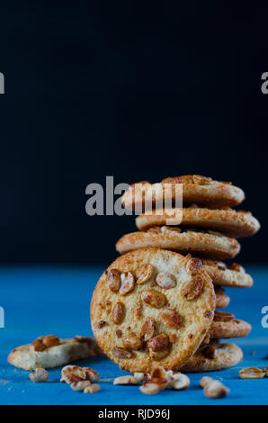 Round orange biscotti con colorati frutti canditi e una fetta di arancia succosa giacente su di un tavolo di legno Foto Stock